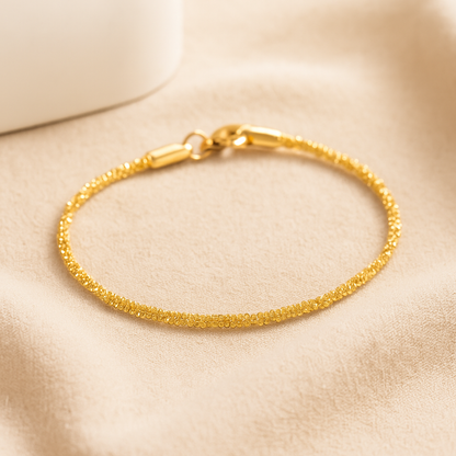 Sparkling gold stainless steel gypsophila bracelet with textured design and secure clasp on neutral background.