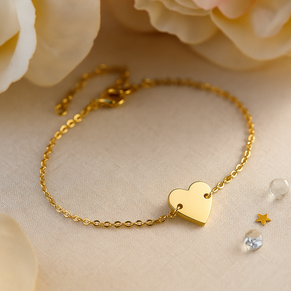 Gold stainless steel chain bracelet with polished heart charm displayed on soft fabric background.