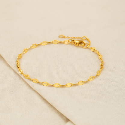 Delicate gold chain bracelet with oval links, adjustable clasp, displayed on neutral background.