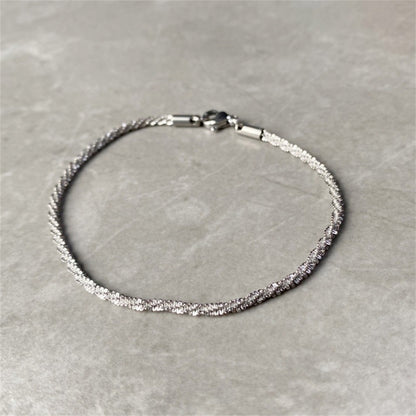 Adjustable silver stainless steel gypsophila bracelet with shimmering texture displayed flat.