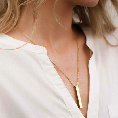 Elegant woman wearing a sleek gold bar pendant necklace with a minimalist stainless steel chain.