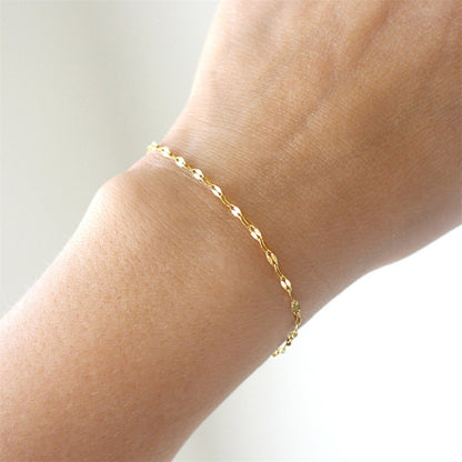 Elegant thin gold stainless steel adjustable bracelet with oval link design on the wrist.