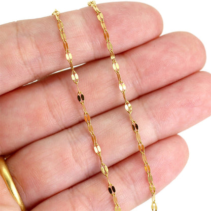Close-up of delicate adjustable gold stainless steel chain bracelet with textured oval links.