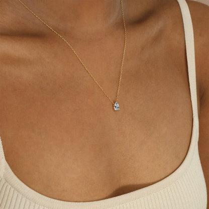Minimalist stainless steel necklace with clear crystal birthstone pendant styled on neckline.